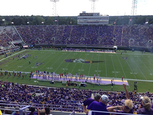 View of the ECU football field with players standing on the sidelines